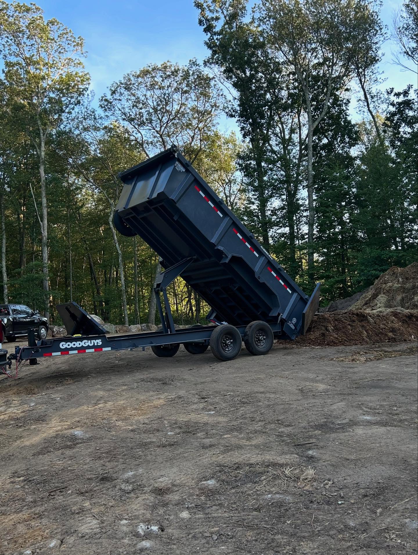 A&M Site Services dump trailer tipping a load at a job site