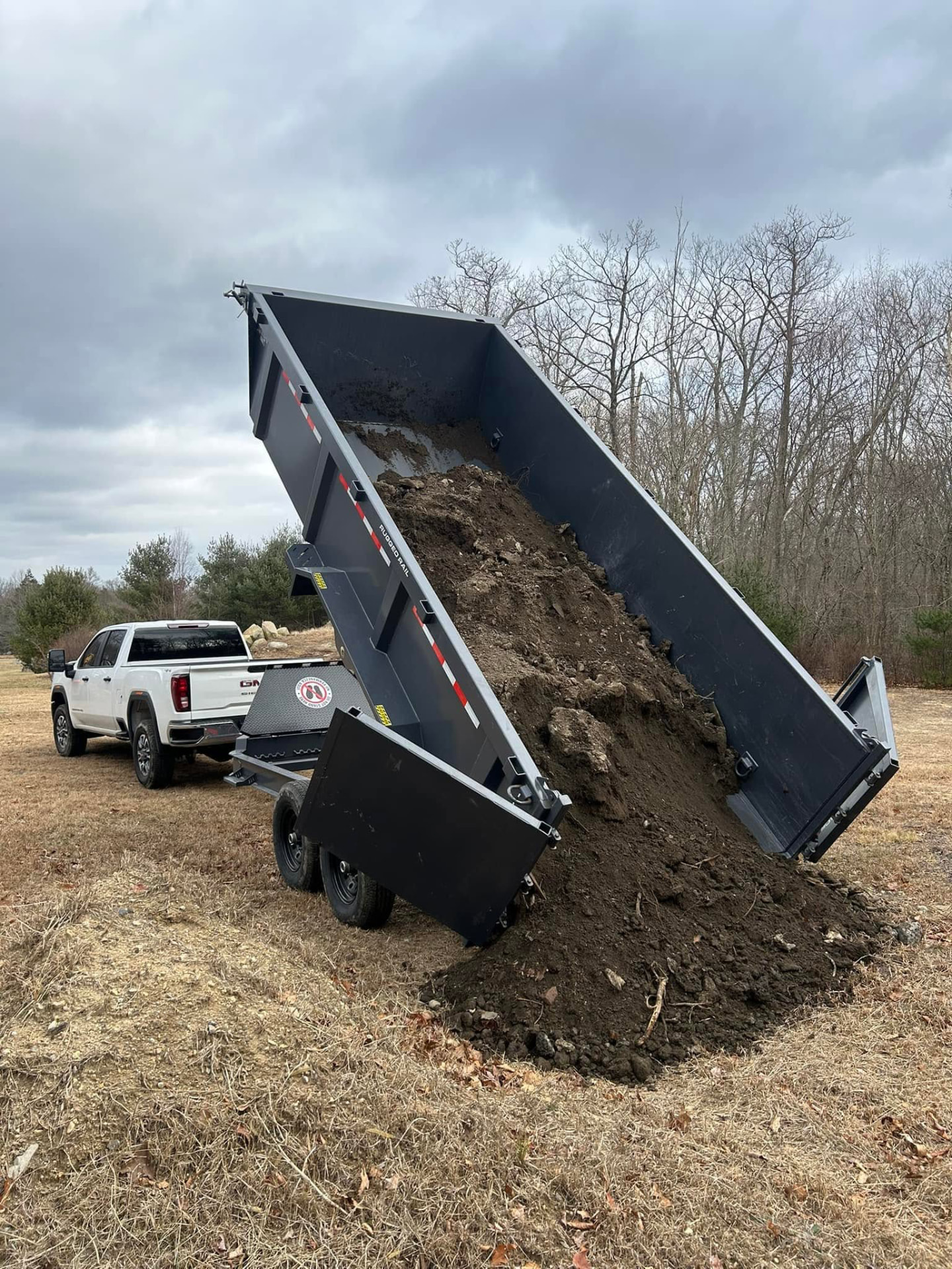Dump trailer unloading fill dirt on a job site